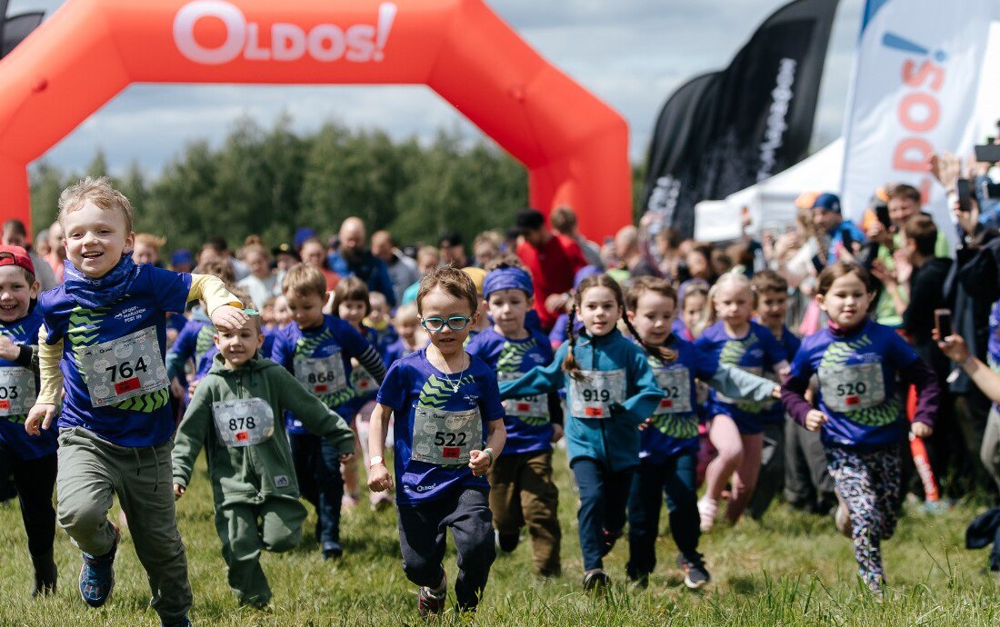 Дети бегут в спортивной одежде по полю.